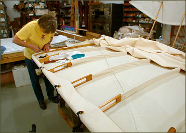 Beverly Hyde attaching the fabric covering to a wing at the Wright Experience.