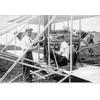 Frank Coffyn and Walter Brookins at an air meet with a Wright transitional aircraft. Brookins appears to be distracted by the photographer while attending to the engine.
