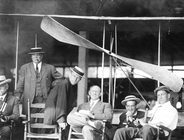 Group of men, including Frank Coffyn (right), behind a Wright aircraft in the boardwalk airplane shed at Atlantic City.