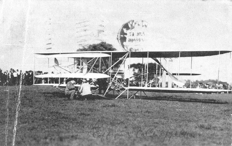 Postcard of Wilbur Wright, Frank Coffyn, and Duval La Chapelle inspecting Wright transitional aircraft.