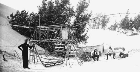 William Paul Butusov poses with his Albatross at the Miller Camp in 1896. Chanute, Herring, and William Avery are seated on the right.