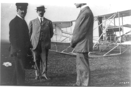 King Victor Emmanuel of Italy at left, with Orville and Wilbur Wright and their airplane, 1909.